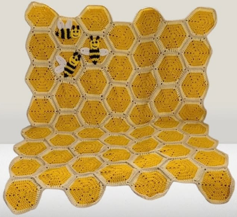 Yellow and cream honeycomb crochet baby blanket with 3D honeybee appliqués and scalloped border, handmade by Johanna Lesley Creations.